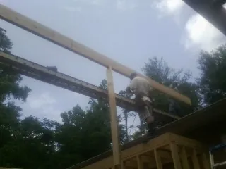 Carpenter setting a ridge beam over a new addition frame — Ice Dam Removal by Roofing Brothers in Teterboro