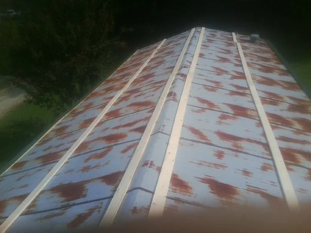 Rusted metal roof panels with new wood purlins before replacement — Storm Damage Roof Repair in Teterboro by Roofing Brothers