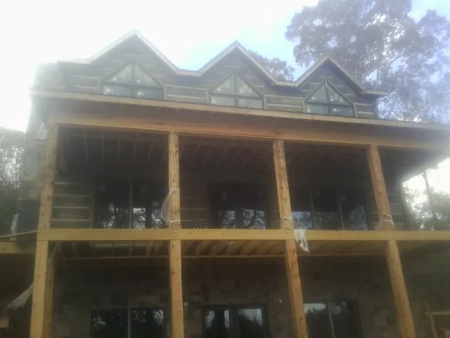 Dormers and porch framing on a large log home under construction — Roof Coating work by our crew in Teterboro