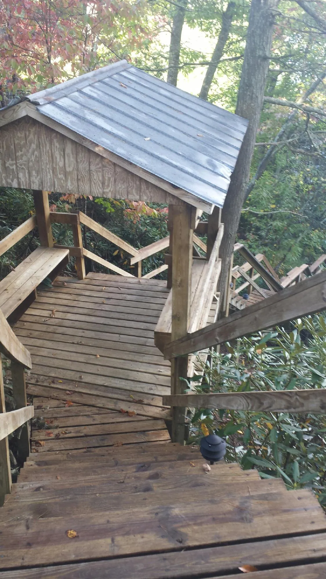 Metal roofed shelter over wooden steps on a wooded walkway — Skylight Repair & Installation work by our crew in Teterboro